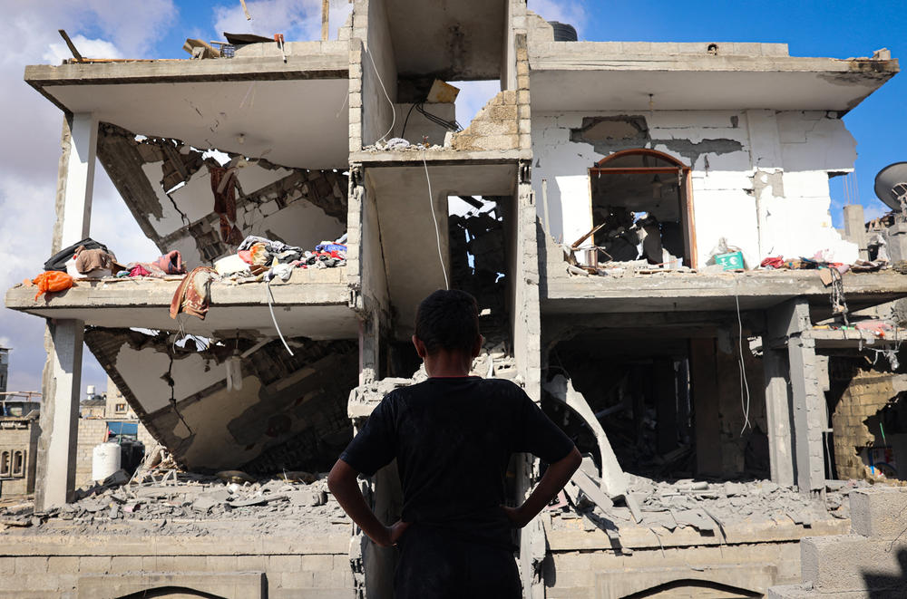A Palestinian youth stands in front of a destroyed building following Israeli bombardment of Rafah's Tal al-Sultan district in the southern Gaza Strip on Tuesday. The Israeli army said it took 