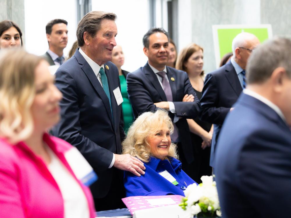 Patti Garamendi (seated in blue) chairs the congressional spouses club. She recently attended a Capitol Hill reception with her husband, Rep. John Garamendi, D-Calif. (standing above her) to tout a bipartisan project aimed at cancer prevention.