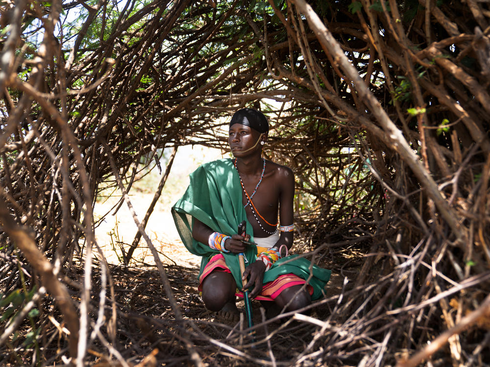 Ltesekwa sits in the shelter where he sleeps at this mountain campsite.