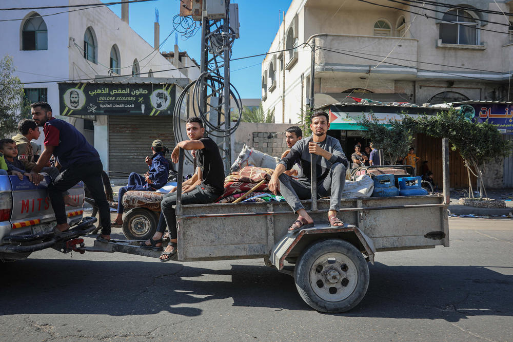 Palestinians on a car trailer flee with their belongings from Gaza City to southern Gaza after being told to leave their homes in the north by the Israeli military, Oct. 13, 2023.