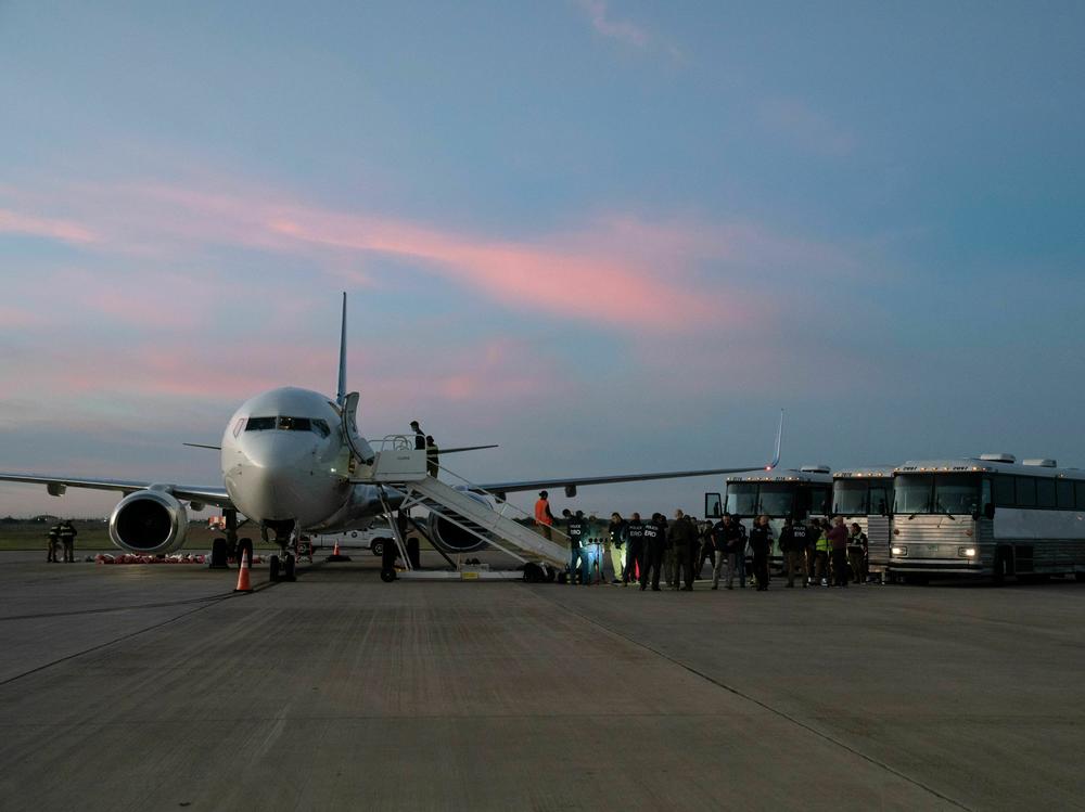In this file photo, migrants board a plane in Harlingen, Texas, on October 18, 2023 for deportation to Venezuela.