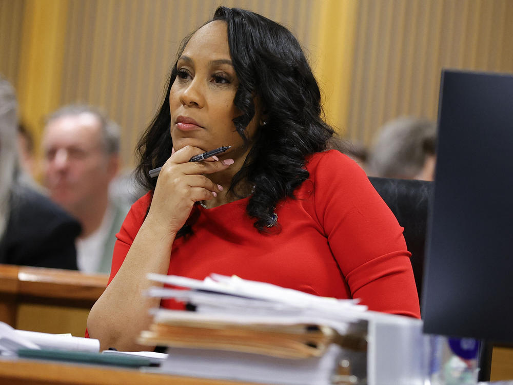 Fulton County District Attorney Fani Willis listens during the final arguments in her disqualification hearing on March 1 in Atlanta. She was allowed to remain on the case if a special prosecutor she hired resigned.