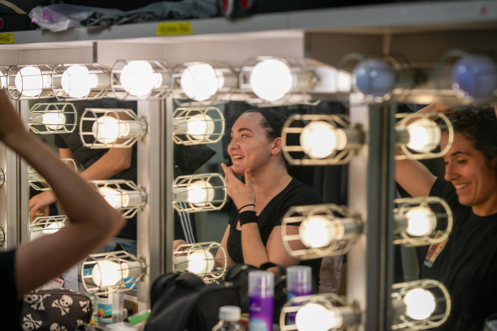 Zoë Brielle Payne, along with other female dancers, puts on makeup for the dress rehearsal.