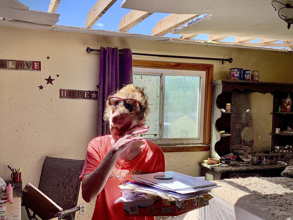 Greenville, Ohio, resident Brenda Pollitt wipes the tears from her eyes as she removes papers from her bedroom on Wednesday. Pollitt and her children were home at the time of the strong storm that hit Tuesday evening. She and her family ran downstairs and were all safe.