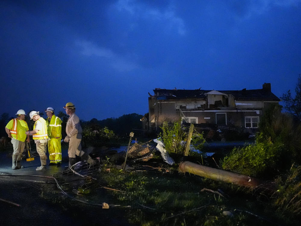 Utility workers survey storm damage along Cothran Road on Wednesday in Columbia, Tenn.