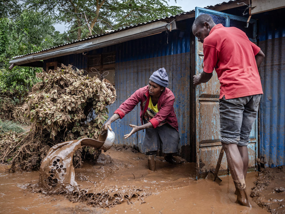 Kenyans try to get mud and water out of their house in Mai Mahiu, an area heavily affected by rains and flooding.