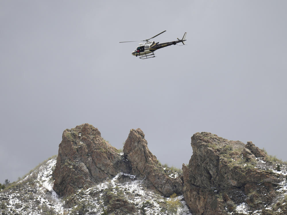 A Utah Department of Public Safety helicopter carries rescuers from Hidden Valley Park on Thursday in Sandy, Utah.