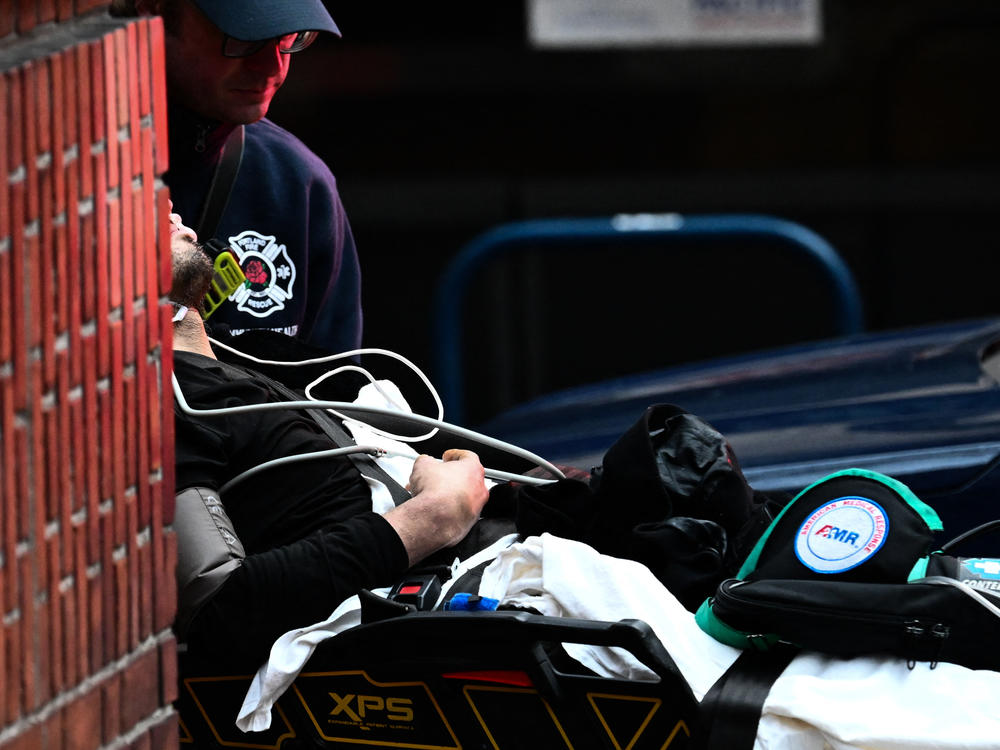 A member of the Portland Fire and Rescue Community Health Assess & Treat team pushes a patient into an ambulance for medical care after they were administered naloxone nasal spray for a suspected fentanyl drug overdose in Portland, Ore., on Jan. 25.