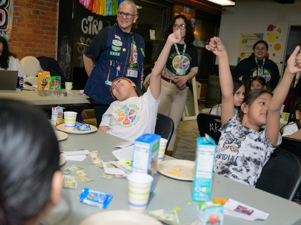 The girls excitedly raise their hands during an activity at Girl Scout Troop 6000's weekly meeting at the Row Hotel on Wednesday evening.