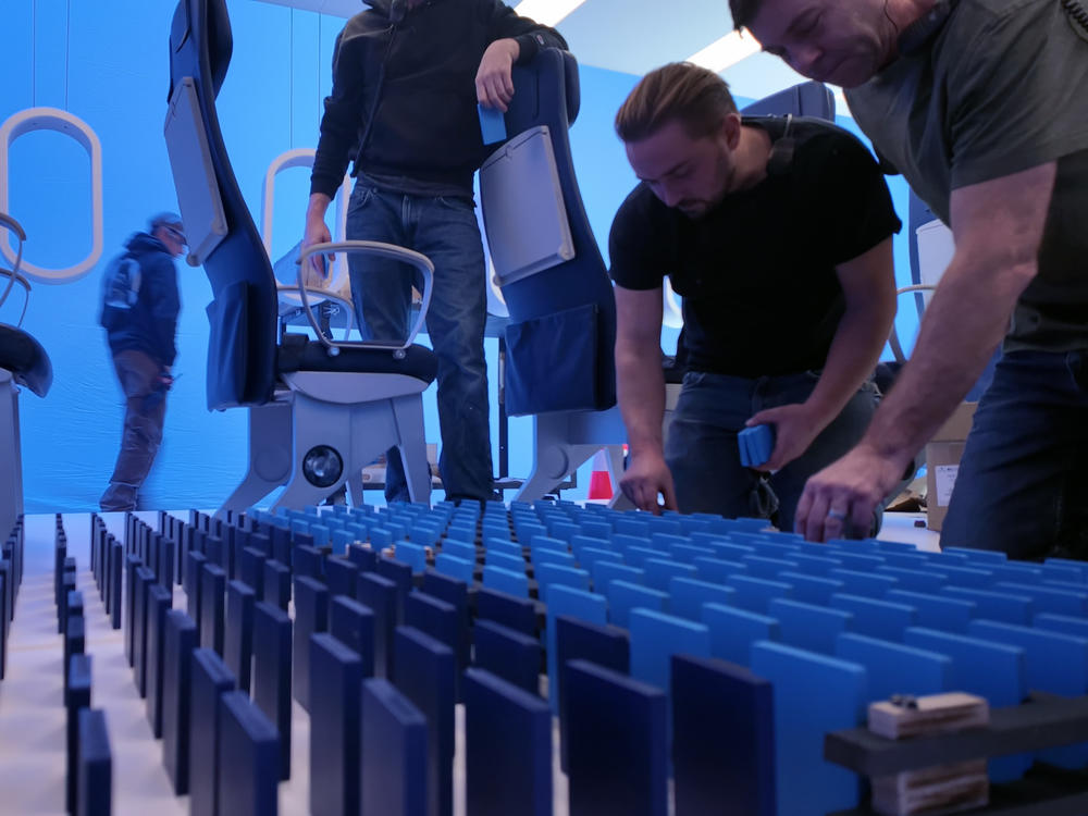 Crew members set up more than 1,000 dominos on the set of United's new safety video.