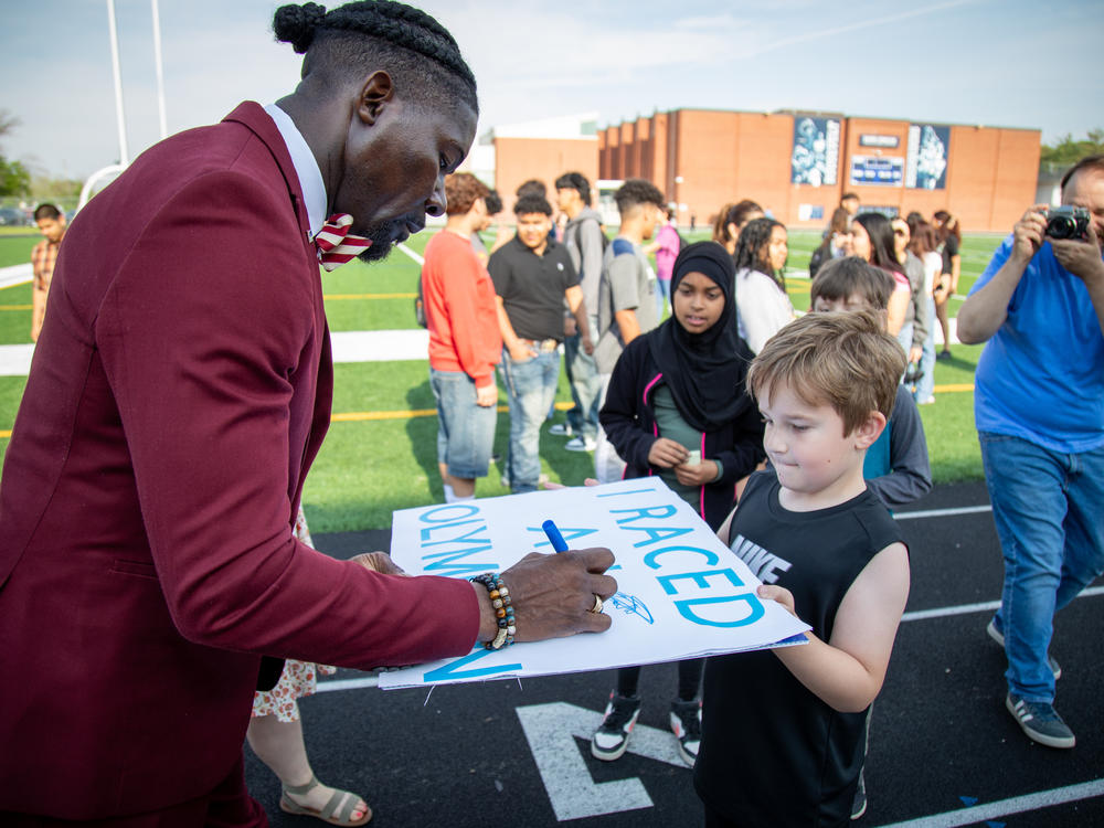 Des Moines Superintendent Ian Roberts autographs a sign for a student.