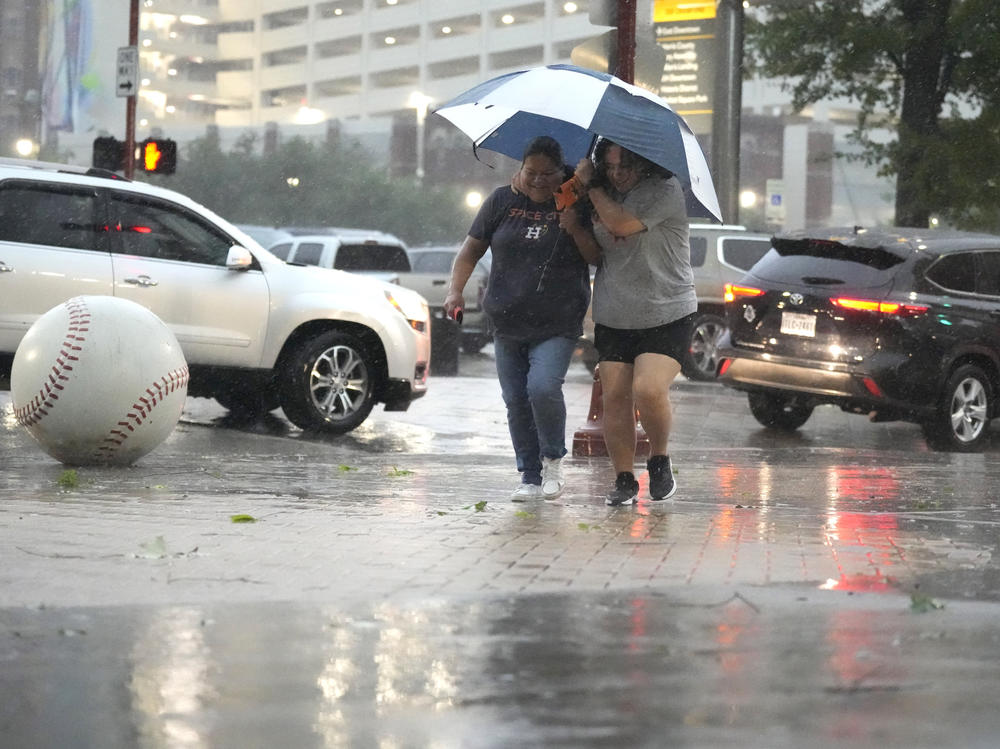 Fans make their way into Minute Maid Park as a severe thunderstorm hit before a baseball game between the Oakland Athletics and the Houston Astros, Thursday, May 16, 2024, in Houston.