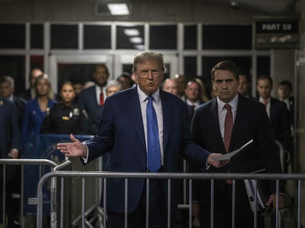Former President and Republican presidential candidate Donald Trump speaks to members of the media before entering the courtroom with his attorney Todd Blanche (right) at Manhattan criminal court in New York City, on Monday.