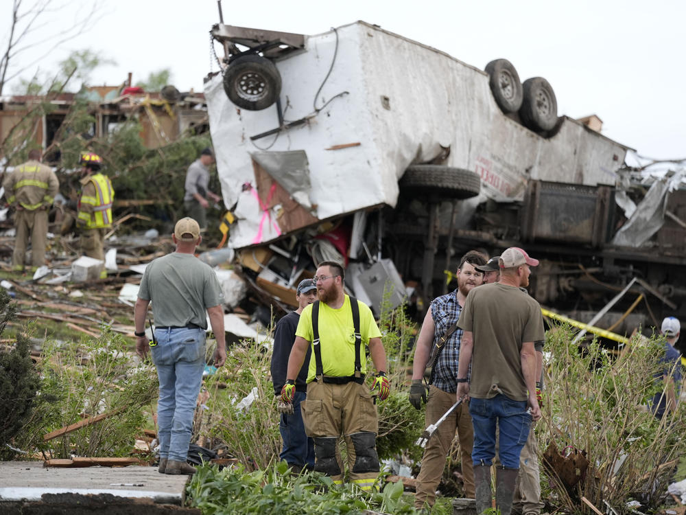 Workers search through the remains of tornado-damaged property Tuesday in Greenfield, Iowa.
