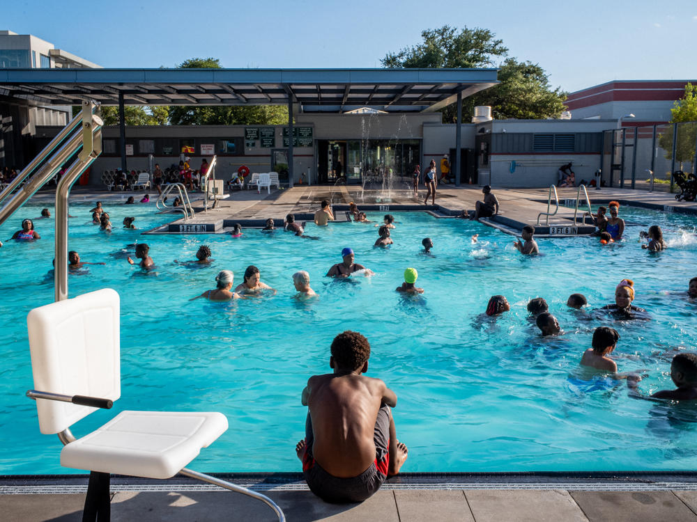 A child watches others swim at the Emancipation Swimming Pool in Houston on July 19, 2022.