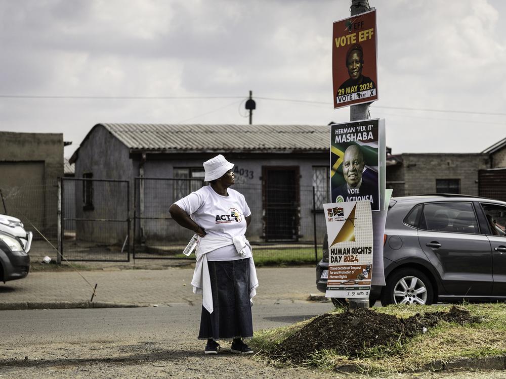 A woman wearing a shirt of African Congress for Transformation party looks at other parties' election posters in Sharpeville, South Africa, on March 21.