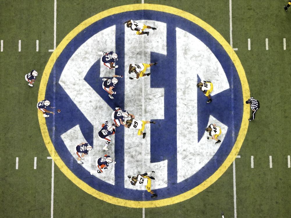FILE - Auburn quarterback Nick Marshall (14), left, takes the snap from Auburn center Reese Dismukes (50) as the Auburn offense operates against Missouri on the SEC logo during the first half of Auburn's 59-42 win over Missouri in the SEC Championship at the Georgia Dome, Saturday, Dec. 7, 2013, in Atlanta, Ga. 