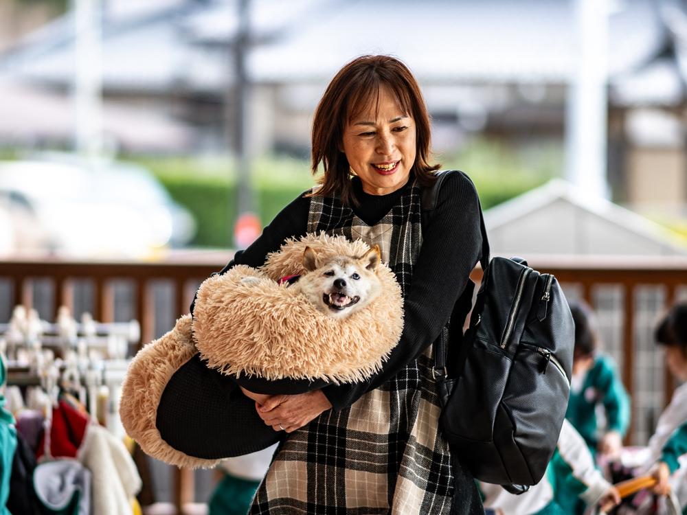 Atsuko Sato is seen with her Japanese shiba inu dog Kabosu, best known as the logo of cryptocurrency Dogecoin, playing with students at a kindergarten in Narita, Chiba prefecture, east of Tokyo, on March 19.