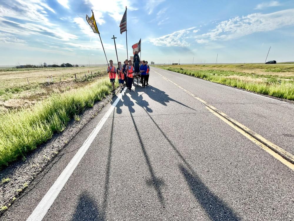  A Catholic parish against abortion rights begins a two-day walk on Interstate 70 west of Watkins, Colo., on Aug. 19, 2022.