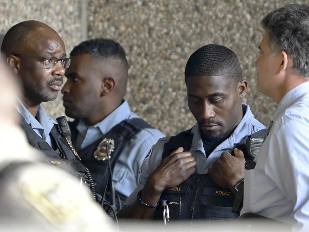 Members of law enforcement gather outside Hennepin County Medical Center in Minneapolis on Thursday following a fatal shooting.