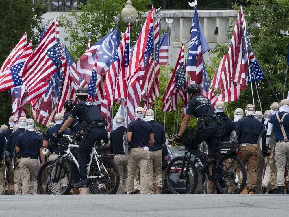 Holding upside down U.S. flags, marchers with the white supremacist group known as the Patriot Front chanted the phrase 