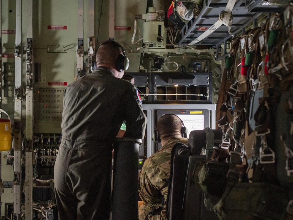 Monitoring weather data on a Hurricane Hunter training sortie. 
