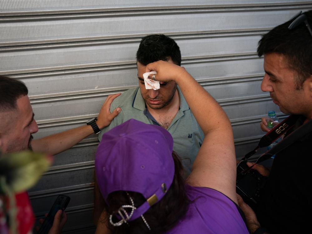 People help a Palestinian journalist who said he was injured by an Israeli police officer while documenting aggression against local shopkeepers on Jerusalem Day. 