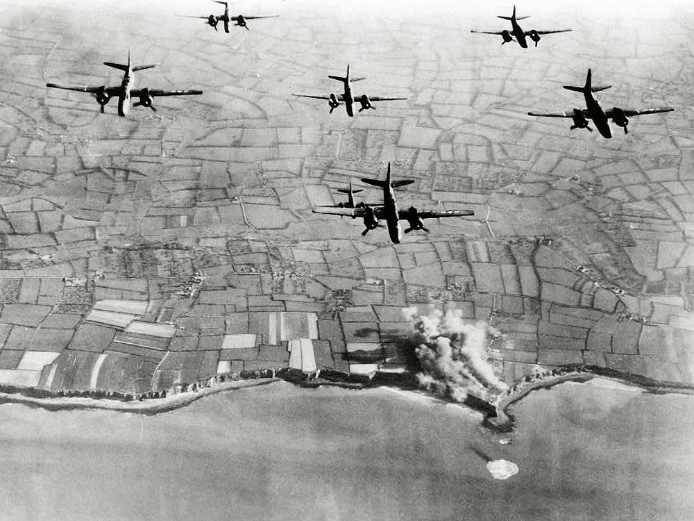 A-20 bombers fly over German positions at the Pointe Du Hoc coastal battery on May 22, 1944, weeks before D-Day. 