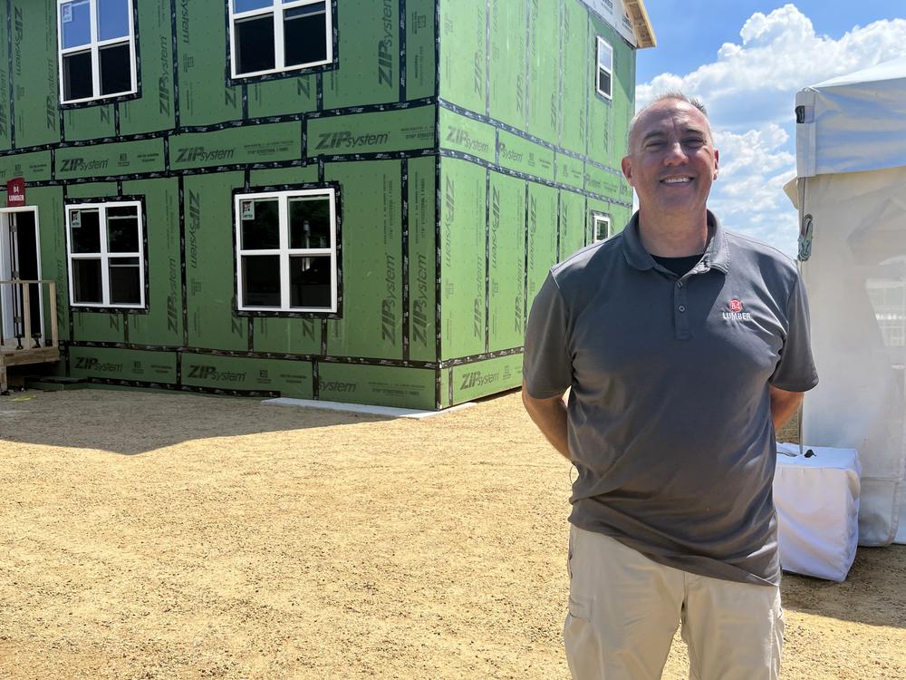 Mark Cyrus, who works for 84 Lumber, stands in front of a home that that was framed in about six hours using prebuilt materials — a job that often takes two weeks with traditional materials.