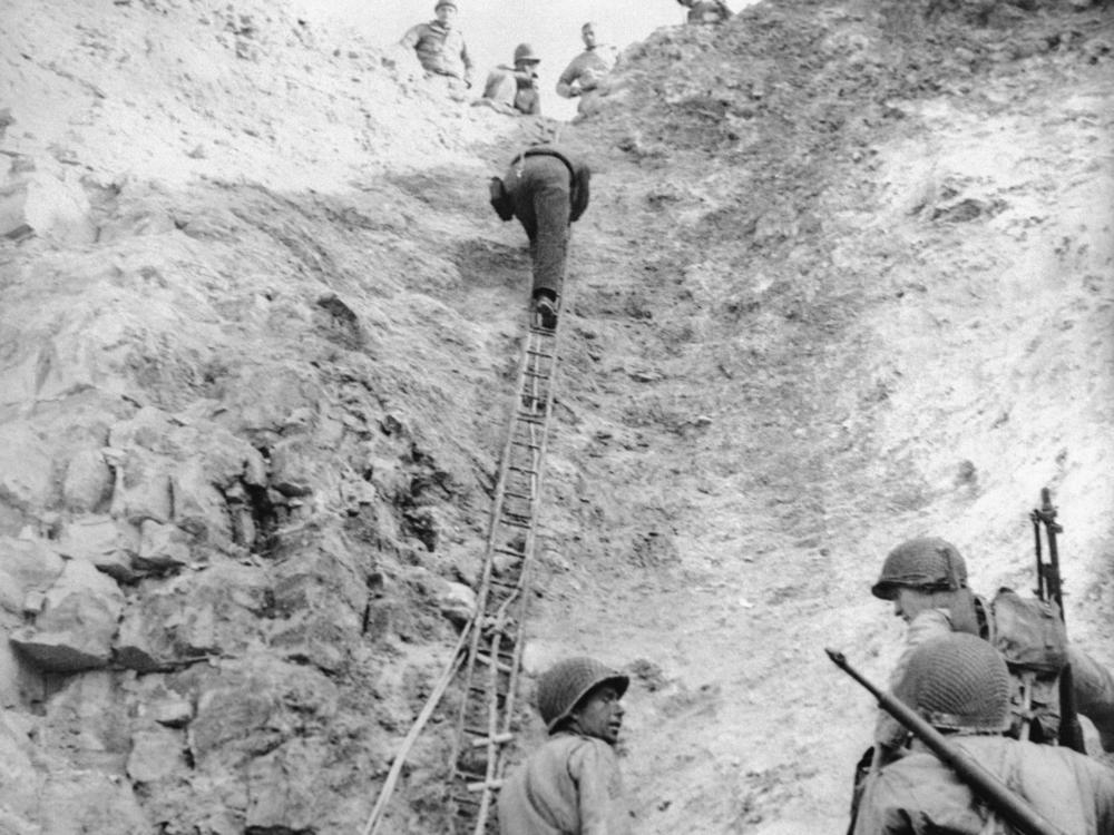  A group of U.S. Army Rangers demonstrate how they climbed a rope ladder up the cliff face at Pointe du Hoc to surprise a Nazi gun position, easing the Invasion of Normandy at Omaha Beach.