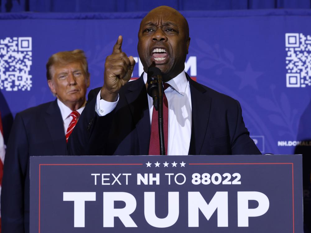 Sen. Tim Scott (R-SC) speaks as Republican presidential candidate and former President Donald Trump looks on during a campaign rally on January 19 in Concord, N.H.