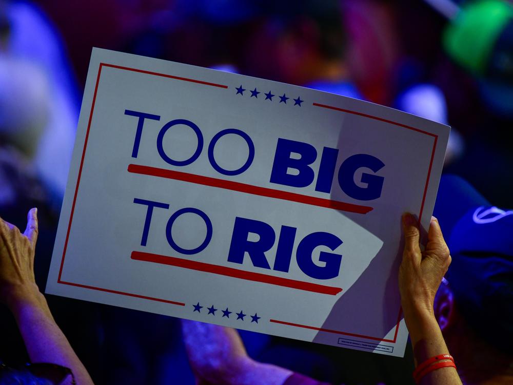 A supporter waves a sign reading 