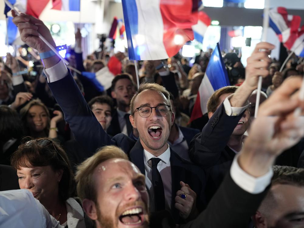 Supporters of the French far-right National Rally react at the party election night headquarters on Sunday in Paris. 