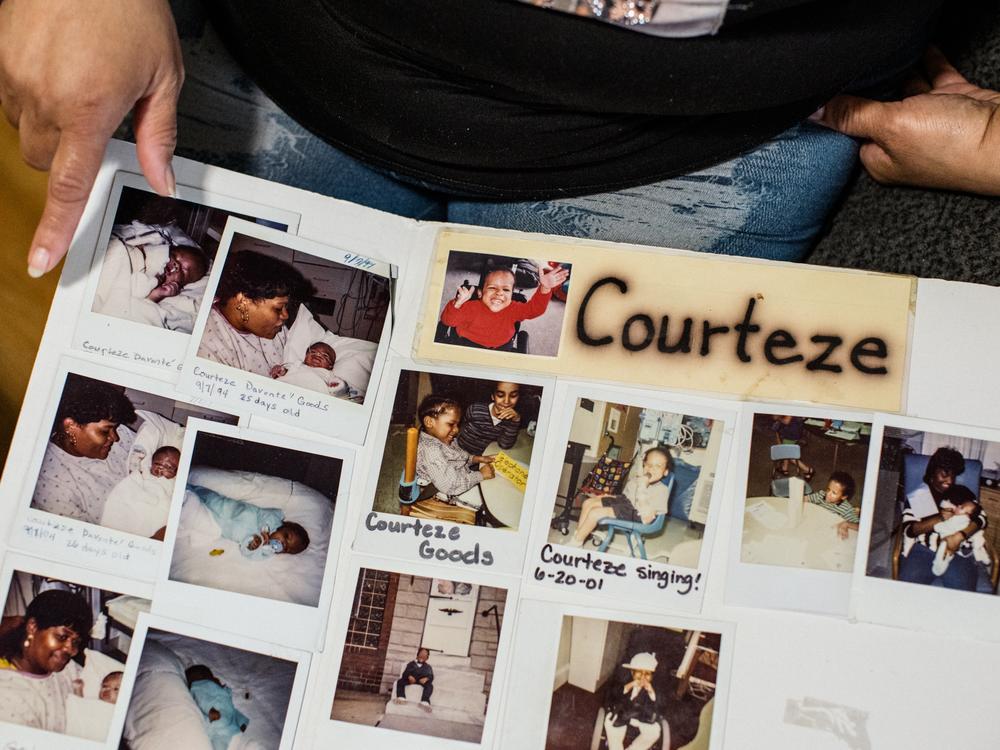 Smith shows a poster board with photos of Goods during his childhood.