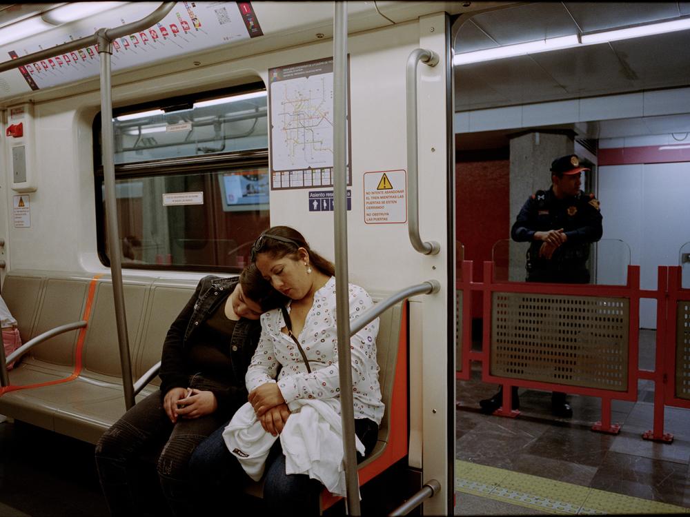 A mother and daughter rest in the women-only section of Mexico City's metro in October 2023. Police monitor the section on the platform to make sure that no men cross the barrier.