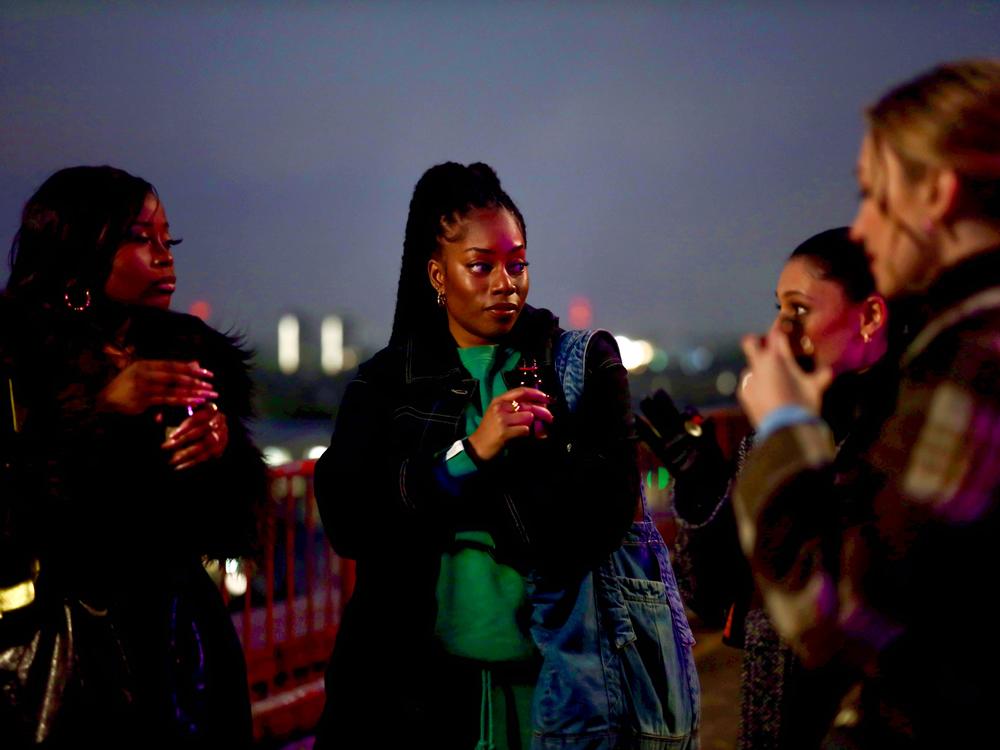 Dionne Brown as Queenie in a scene with her best friend Kyazike, played by Bellah.  