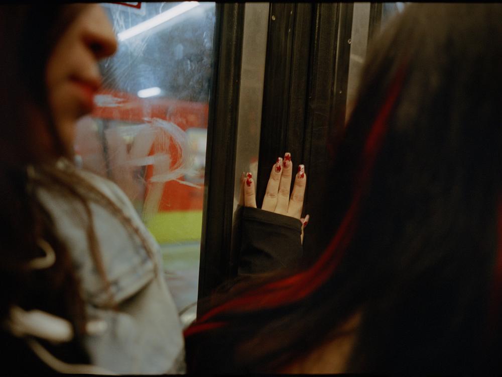 A woman places her hand on the metro car sliding door in December 2023.