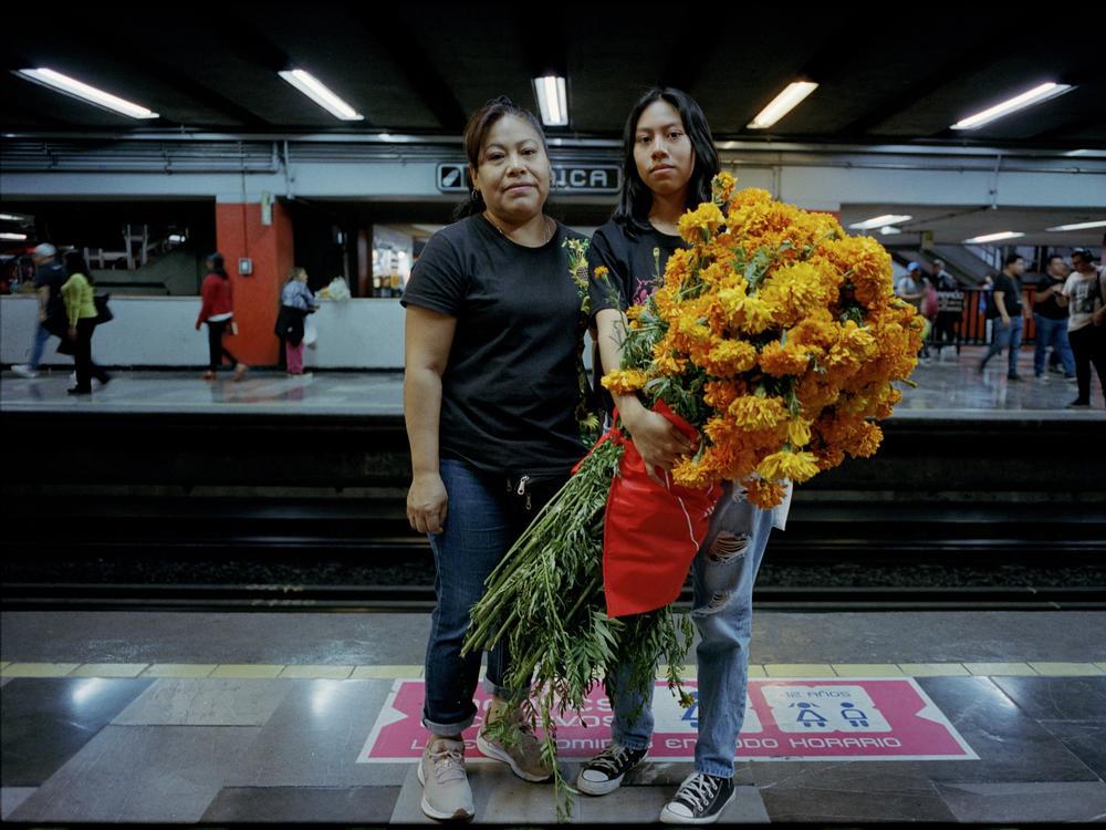 A mother and daughter travel on the city's metro's women-only section with flowers from Mercado Jamaica for Día de los Muertos in October 2023.