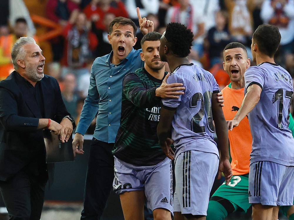 Real Madrid's Brazilian forward Vinícius Júnior (3R) confronts Valencia's officials as he leaves after being sent off the pitch by the referee during the Spanish league football match between Valencia CF and Real Madrid CF at the Mestalla stadium in Valencia on May 21, 2023. 