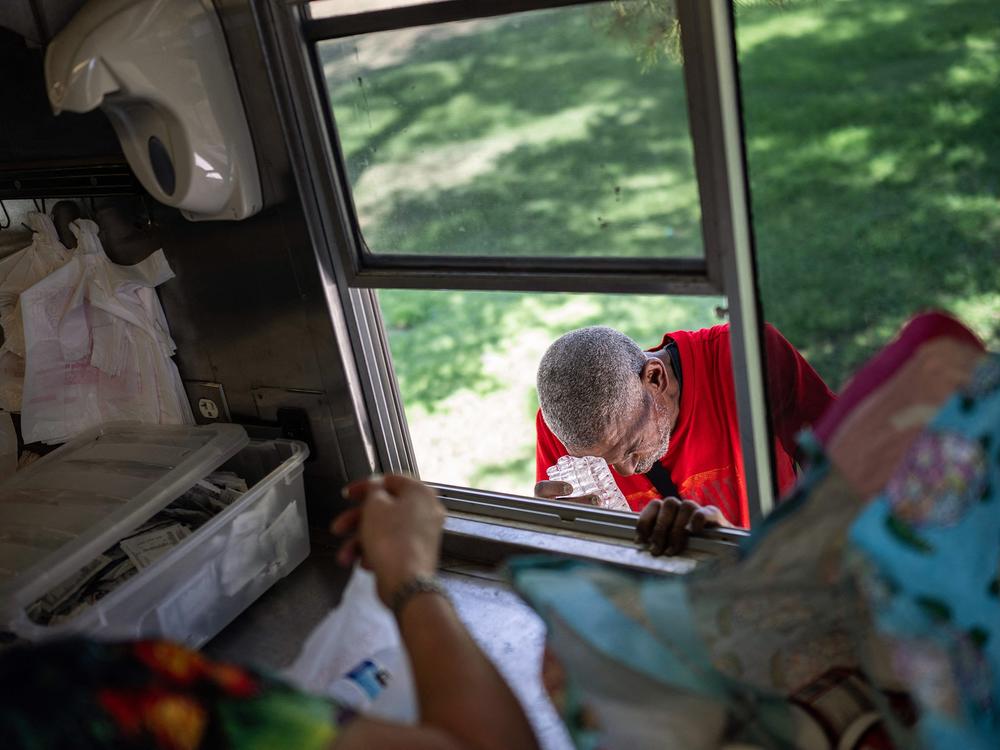Joseph Guillory rubs his head with ice given to him at a Salvation Army truck handing out water and other supplies in Tucson in July of last summer. Hess' office reported 120 heat-related deaths that month. Maricopa County, which includes Phoenix, reported 645 heat-related deaths in 2023.