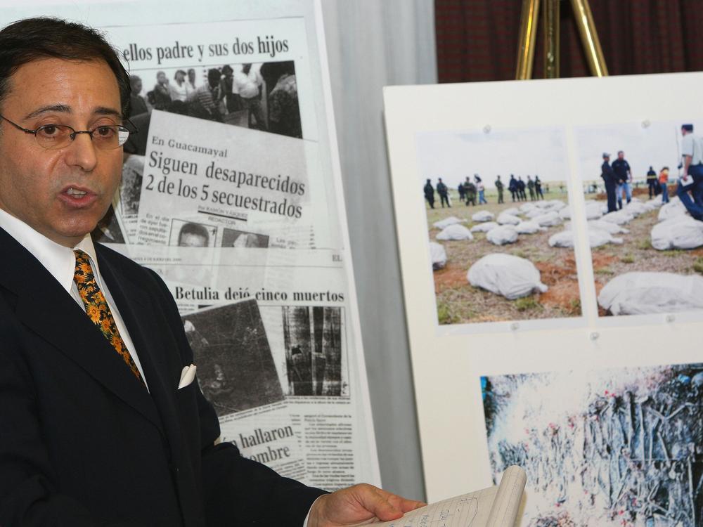 A file photo from 2007 show lawyer Jonathan Reiter discussing a lawsuit against Chiquita Brands International, speaking next to newspaper clippings and photos displaying stories of alleged torture and killing by Colombian paramilitaries who were paid by the banana giant.