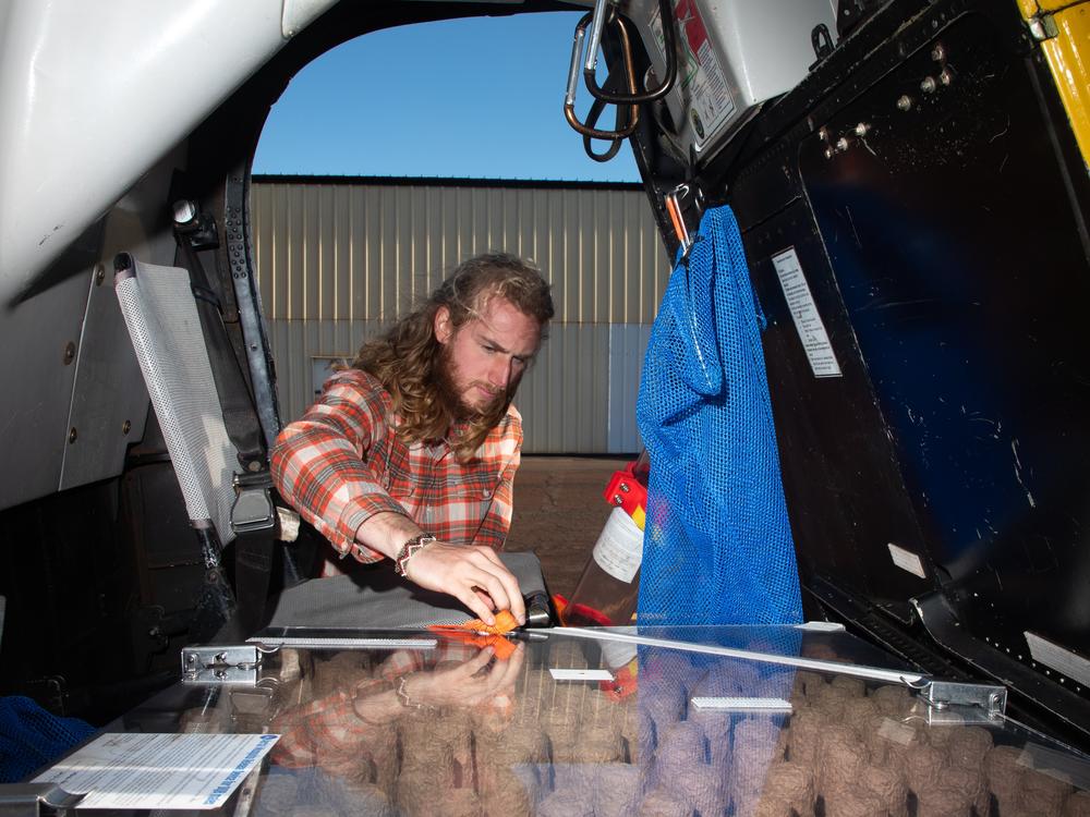 Field associate Aidan Callahan prepares for the day's work just before changing into his flight suit.
