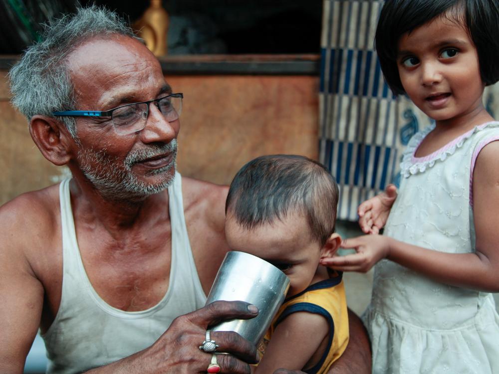 Chandrika Mahato, who guesses he is in his 70s, sits with his grandchildren on the main road of the Sanjay Camp informal settlement in central New Delhi. Mahato fixes bicycles for a living and sleeps on a raised platform above his hole-in-the-wall shop. To cool down during the heatwave, he says he tries to bathe, if there’s enough water, and turns on his fan, if there’s electricity — there are frequent blackouts here.
