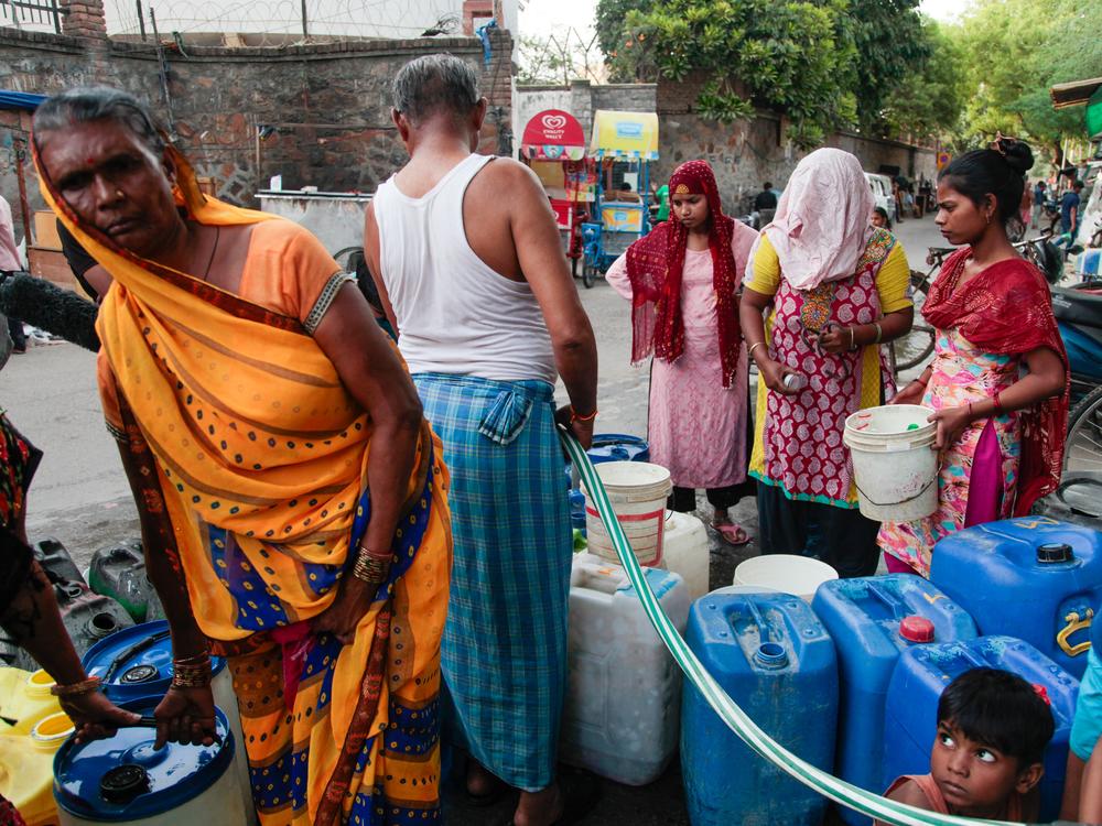 Residents gather around a water pump in Sanjay Camp. The settlement doesn't have running water, and relies on this water pump. Government water tankers also come by. And yet residents say it's not enough. On one of the hottest days this year, a journalist captured footage of residents chasing a water tank, with men leaping onto the moving vehicle and women banging the sides.