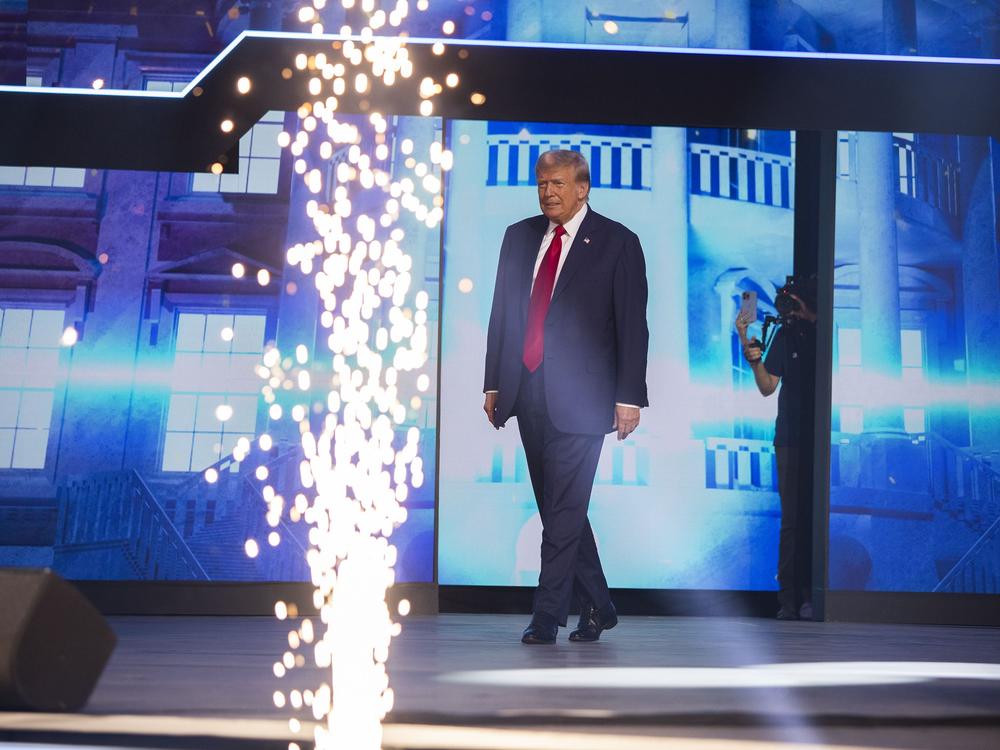 Former President Donald Trump walks on to the stage to give the keynote address at Turning Point Action's 