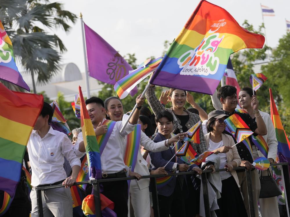 Participants wave flags celebrating marriage equality at the government house in Bangkok, Thailand, Tuesday. Thailand's Senate voted overwhelmingly to approve a marriage equality bill.