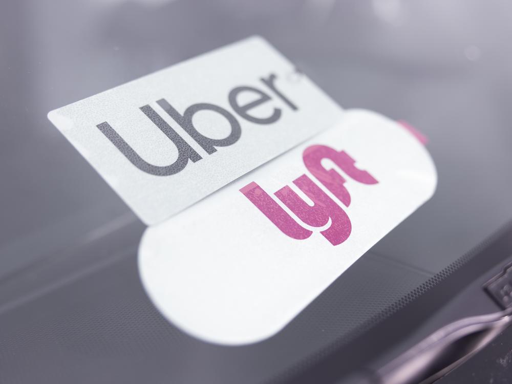 Symbols for Uber and Lyft adorn Farhan Badel’s vehicle in Apple Valley, Minn.