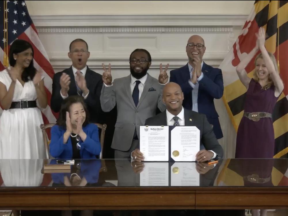  Gov. Wes Moore, center, holds an executive order authorizing pardons for at least 175,000 criminal convictions related to marijuana. Legalization, Moore said, “doesn't erase the fact that Black Marylanders were three times more likely to be arrested for cannabis than white Marylanders before legalization.
