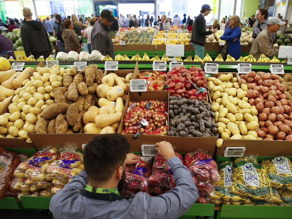 An employee arranges a digital price tag for vegetables at the Whole Foods store in the Silver Lake neighborhood of Los Angeles.
