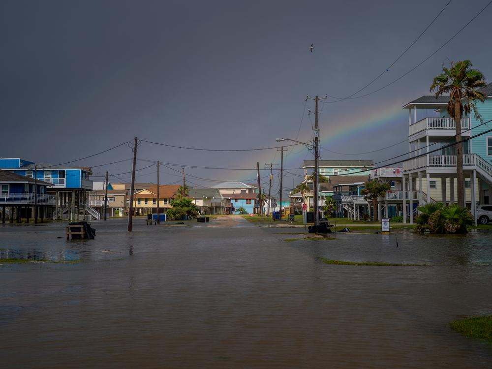 A rainbow appears behind a flooded neighborhood in Jamaica Beach, Texas, on Thursday.